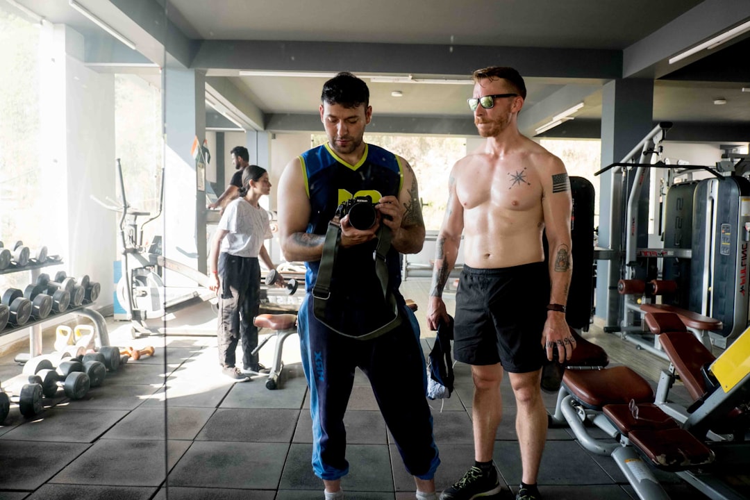 a-couple-of-men-standing-next-to-each-other-in-a-gym-lxw-a2yzzro